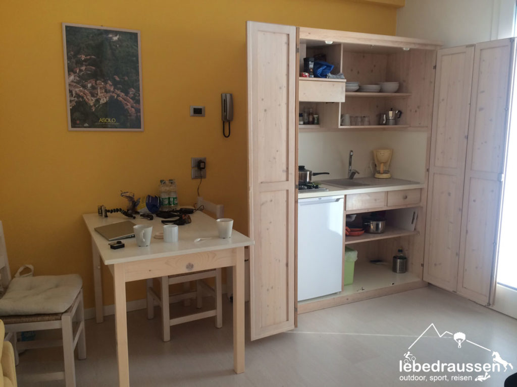 Ein Esstisch und die praktische Küche im Schrank